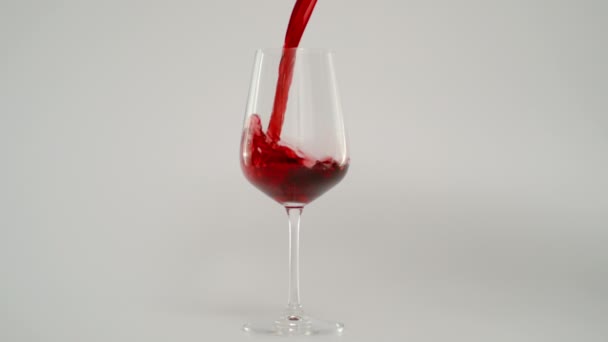 Rode wijn gieten in glas op 1000 fps, Super Slow Motion Shot, witte achtergrond - Video