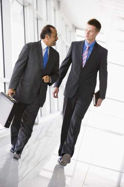 Businessmen walking through office lobby - Zdjęcie, obraz