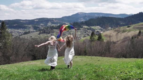 Lesbičky s vlajkou LGBT běží ve svatebních šatech - Záběry, video