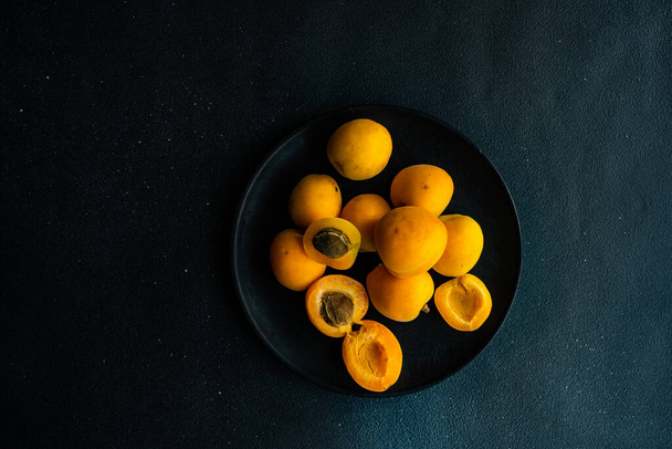 Summer background with ripe apricots on wooden plate - Fotoğraf, Görsel