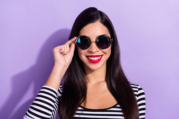 Photo of charming sweet young woman dressed striped outfit arm dark glasses smiling isolated violet color background - Φωτογραφία, εικόνα
