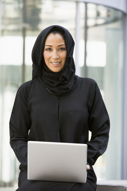 A Middle Eastern business woman sitting with a laptop - Foto, imagen
