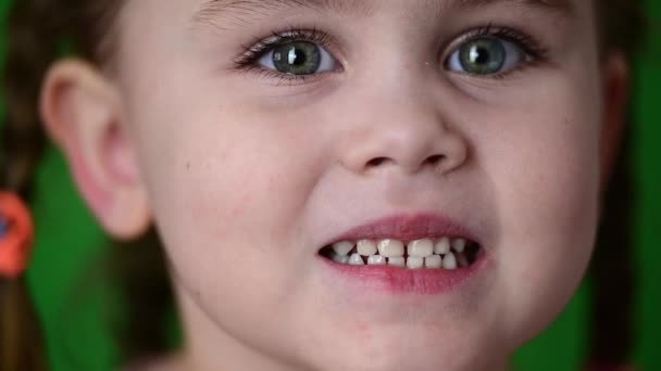 La ragazza mostra i denti da latte, i denti da latte bianchi, l'igiene orale, il movimento lento del bambino. - Filmati, video