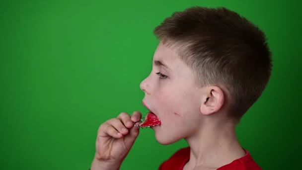 A gyermek tesz egy tányért a fogak, lassított felvétel, oldalnézetben egy gyermek, egy fiú a zöld háttér. - Felvétel, videó