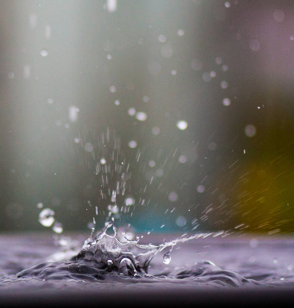 Water spray from a drop falling into the water. Splash on the water surface - Фото, изображение
