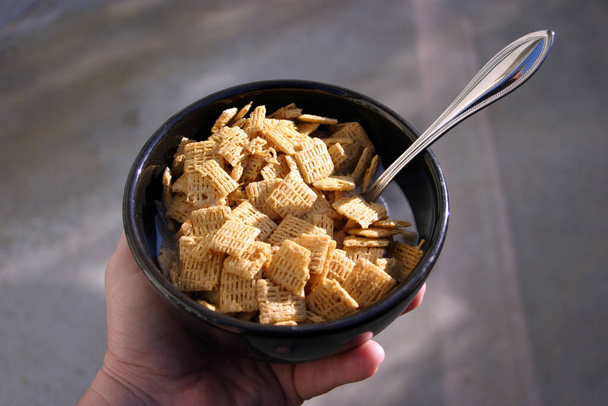 Cereal en un tazón de leche. Comida de desayuno. Cereales para el desayuno en un bol negro con leche. El desayuno es la comida importante de la mañana para empezar bien el día.. - Foto, imagen