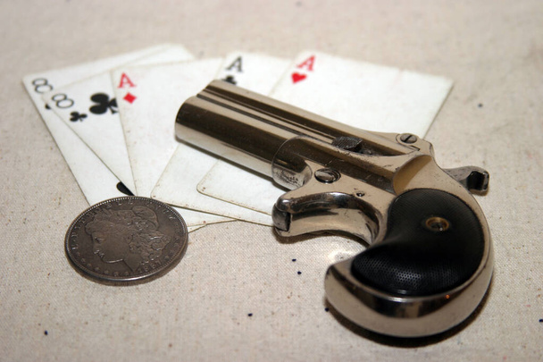 Genuine Antique 1887 Double Derringer Pocket Pistol Ізольований на білому з місцем для вашого тексту або інформації. Близько 1889, модель 95, модель II Модель 3 Подвійний Деррінгер в картковій таблиці з асами і восьмами, які називаються "Мертві руки". Рука мертвої мани.  - Фото, зображення