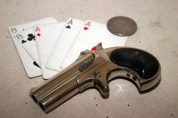 Genuine Antique 1887 Double Derringer Pocket Pistol. Isolated on white with room for your text or information. Circa 1889, Model 95, Type II Model 3 Double Derringer on card table with aces and eights aka a Dead Mans Hand. Dead Mans Hand.  - Photo, Image
