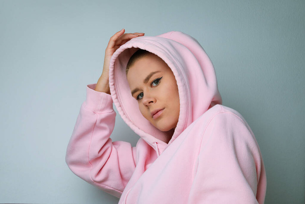 Close-up of young woman posing on white background, with the hood over the heads - Foto, Imagem