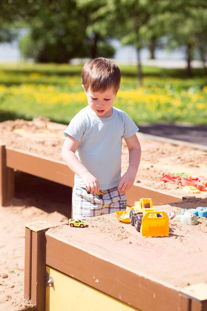 Chlapeček si hraje s hračkami, auta v písku na hřišti - Fotografie, Obrázek