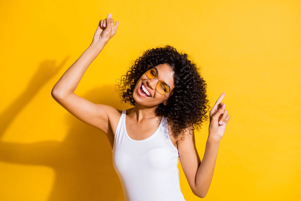 Pozitif afro-amerikan kızının fotoğrafı parmaklar dans ediyor disko yazı rahatla izole edilmiş sarı renkli arka plan - Fotoğraf, Görsel
