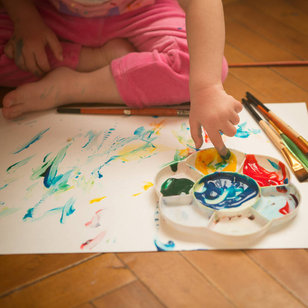 Девушка с синдромом Дауна, покрытая краской при рисовании - Фото, изображение