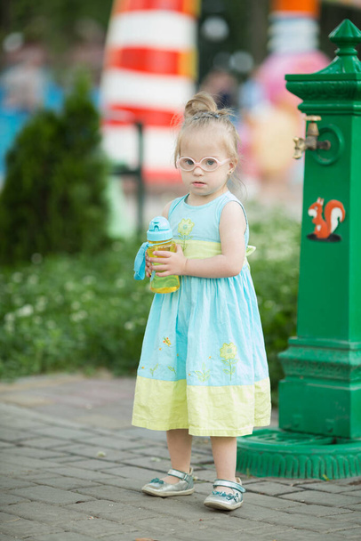 αστείο κοριτσάκι με σύνδρομο Down βόλτα στο πάρκο - Φωτογραφία, εικόνα