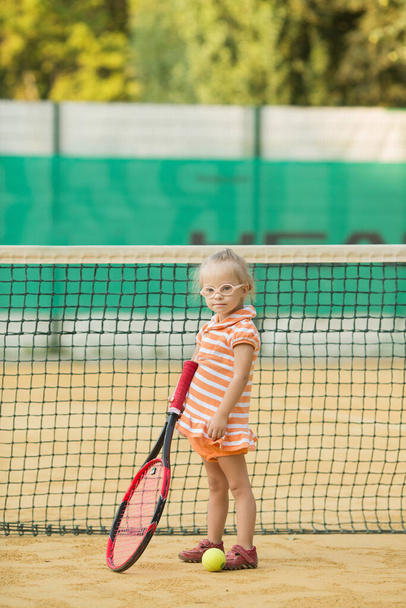 schönes Mädchen mit Down-Syndrom beim Tennisspielen - Foto, Bild