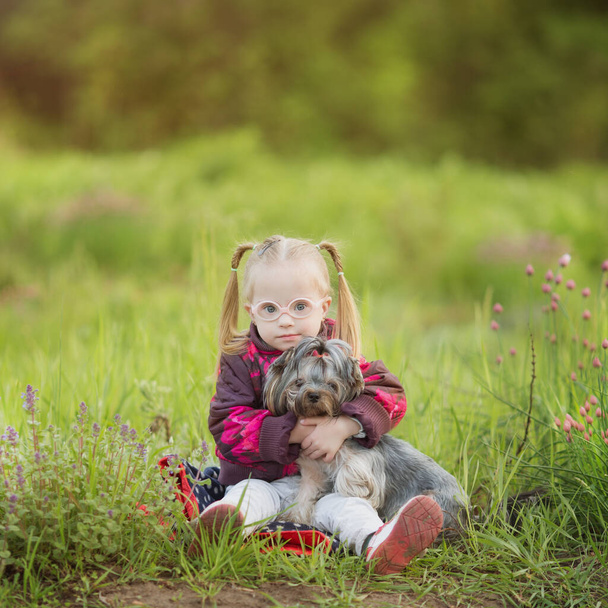 hermosa chica con síndrome de Down abraza cachorro - Foto, Imagen