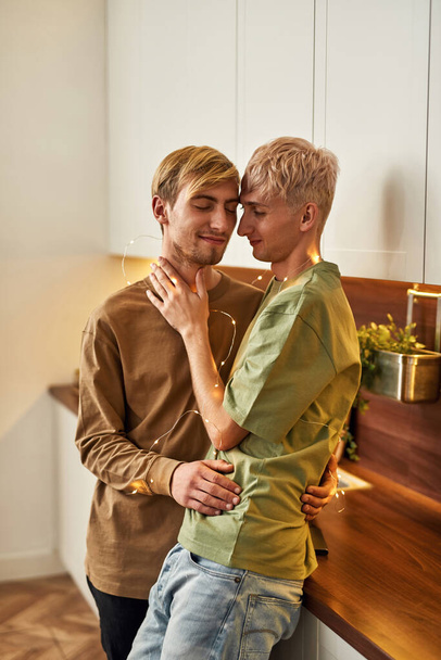 Happy homosexual gay couple with sparkling garland - Фото, изображение