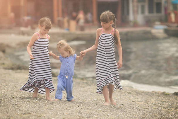 sorelle più grandi stringere le mani la sua sorella più giovane bella con la sindrome di Down
 - Foto, immagini