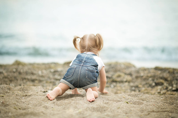 Κορίτσι με σύνδρομο Down αστείο σέρνεται στην παραλία - Φωτογραφία, εικόνα