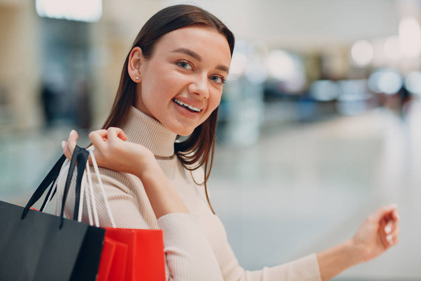 Νεαρή γυναίκα με τσάντες για ψώνια στο κατάστημα λιανικής. Καλοκαιρινό. Πωλήσεις, ψώνια, fashion lifestyle - Φωτογραφία, εικόνα