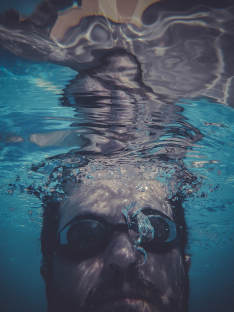dwimmer, man swimming underwater in a pool - Valokuva, kuva