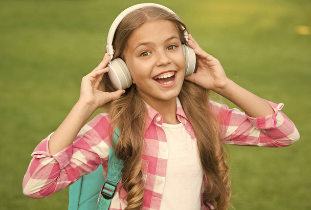 Headphones designed to help you relax. Happy baby wear headphones outdoors. Small child listen to music in headphones. Modern design headphones. New technology. Cool gadget - Zdjęcie, obraz