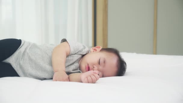 Asian little baby girl sleeping on bed in bedroom at home, toddler napping, newborn adorable is oversleep for relaxation, cute child relax and growth, childhood is sleepyhead in bedtime, indoor. - Footage, Video