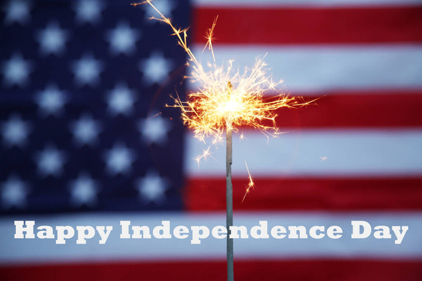 Amerykański Dzień Niepodległości. Szczęśliwego 4 lipca. Dzień Niepodległości USA. Amerykańska flaga. 4 lipca. Złoty Sparkler płonie w tle amerykańskiej flagi. Amerykańska duma. Szczęśliwego 4 lipca tekst.  - Zdjęcie, obraz