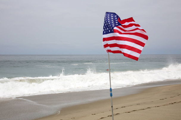 Amerikan itsenäisyyspäivä. Hyvää itsenäisyyspäivää. USA:n itsenäisyyspäivä. Amerikan lippu. Heinäkuun neljäntenä. Amerikan itsenäisyyspäivän juhla. American Flag hiekassa rannalla AMERICA. Amerikka on vapauden ja elämänlaadun ykkönen.. - Valokuva, kuva