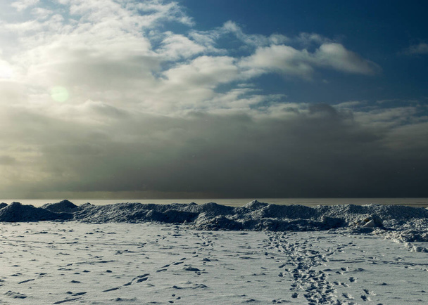 χειμερινό τοπίο δίπλα στη θάλασσα, χιονισμένα κομμάτια πάγου δίπλα στη θάλασσα, αμμόλοφοι καλυμμένοι με ένα λευκό στρώμα από λαμπερό χιόνι, χειμώνας - Φωτογραφία, εικόνα