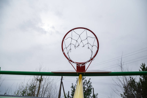 Imagem do anel de basquete vermelho no dia nublado no verão - Foto, Imagem