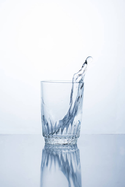 Alcoholic drink or water in a glass, splash, splash - Foto, afbeelding