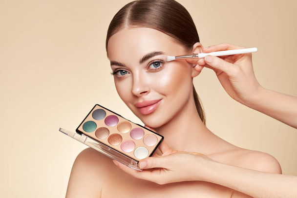 Makeup Artist applies Eye Shadow. Beautiful Woman Face. Perfect Makeup. Make-up detail. Beauty Girl with Perfect Skin. Nails and Manicure. Eye Shadow Palette - Fotó, kép