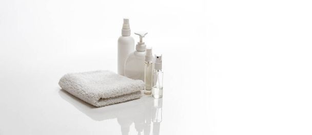 toalla de spa blanco y frascos con botellas de cuidado corporal - Foto, Imagen