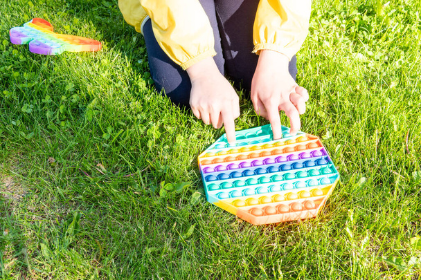 Helles Regenbogenspielzeug Antistress für Kinder und Erwachsene auf buntem Hintergrund. - Foto, Bild