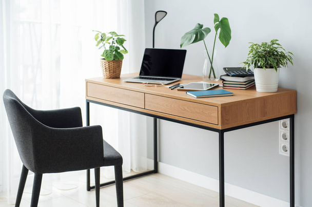 Офісне робоче місце з ноутбуком на дерев'яному столі
 - Фото, зображення