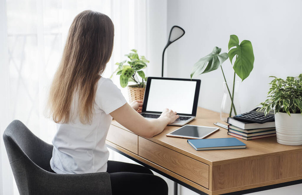 Молодая девушка работает в домашнем офисе за столом - Фото, изображение