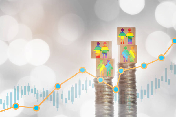 LGBT lesbian gay bisexual transgender rainbow model on wooden cube on stack of coins on growth graph bokeh background. Making money with saving concept and trading return on investment roi idea - Photo, Image