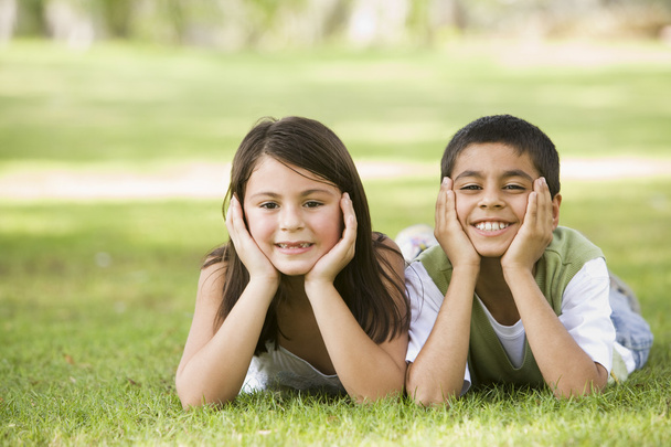 Two children relaxing in park together - Foto, imagen