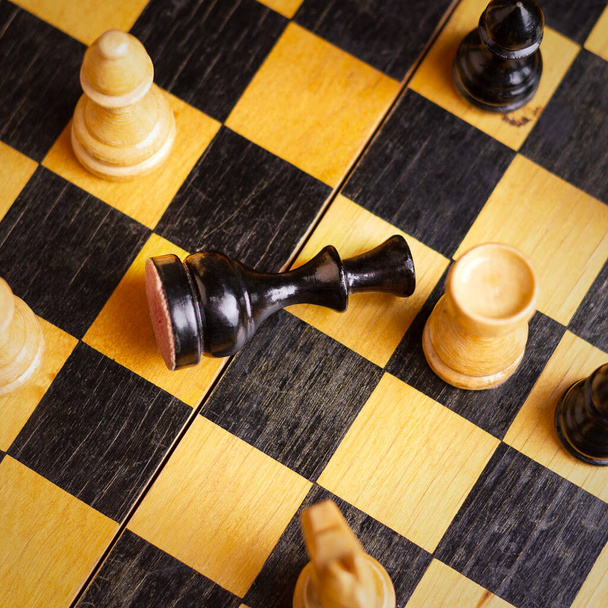 黒の王はチェス盤の上にある。選択的フォーカス。最上階だ。敗北だ。悪い戦略の概念。スポーツだ。仕事だ。背景. - 写真・画像