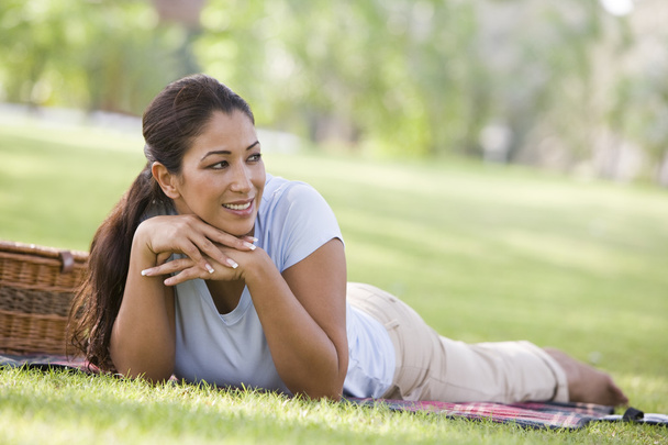 Woman relaxing in park with picnic basket and rug - Photo, Image