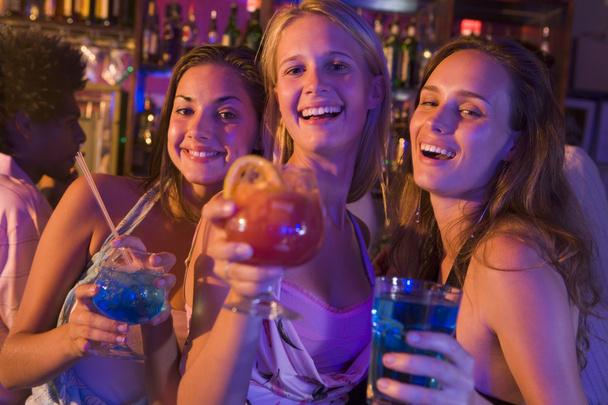 Three young women with drinks in a nightclub - Zdjęcie, obraz