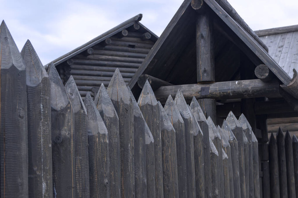 Bir Rus köyünde ahşap bir ahşap evin etrafında koruyucu bir çit. Geleneksel Rus kulübeleri.. - Fotoğraf, Görsel