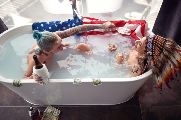 Two lesbian girls having fun together in bathtub; Sinful life concept - Photo, image