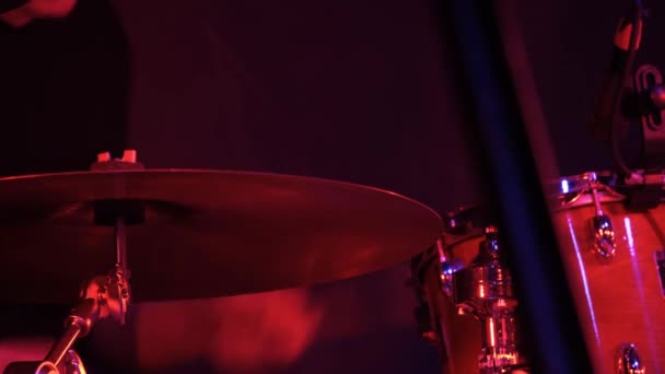 Чоловік барабанщик грає на барабанах на рок-концерті в клубі. Червоне освітлення, крупним планом
. - Кадри, відео
