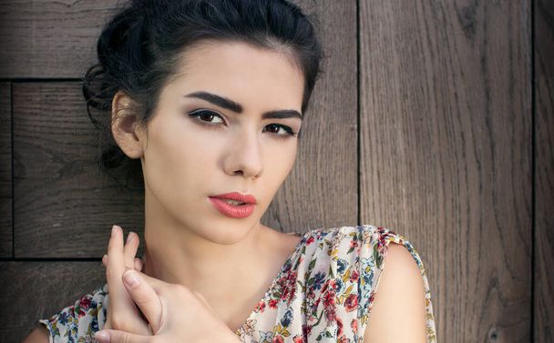 beautiful brunette posing on a wooden wall background - Fotografie, Obrázek
