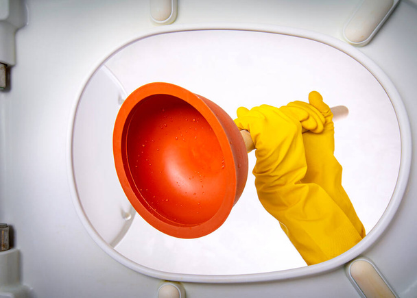 Clogged sewer. Bathroom toilet plunger suction in a hands gets in the toilet. Inside view of the toilet. - Foto, Bild