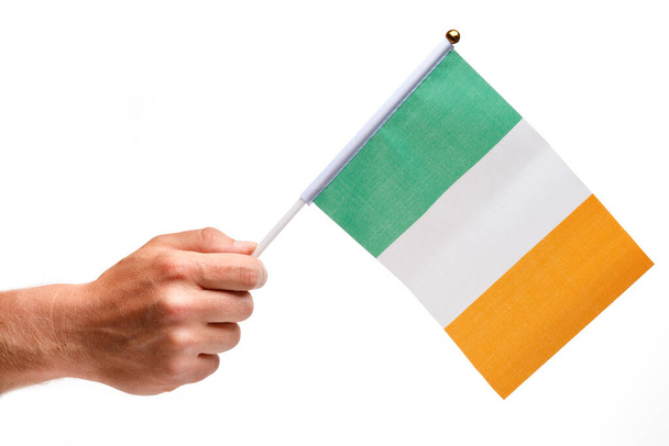 Bandera de Irlanda pequeña en mano aislada. - Foto, imagen