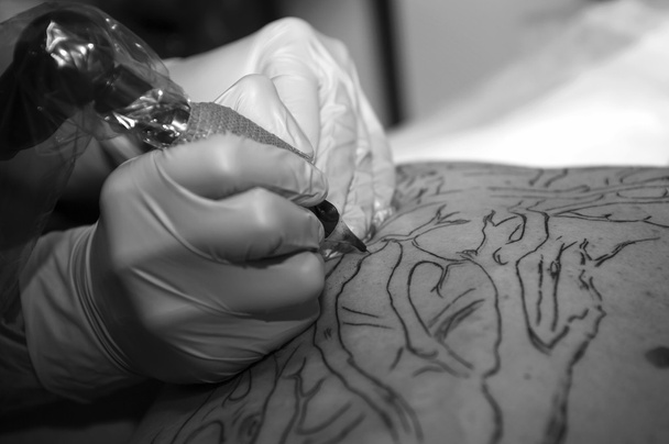 Tattooer does a tattoo - Photo, Image