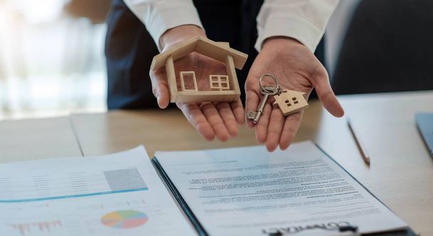 Hausmodell und Schlüssel für Finanz- und Bankenkonzept auf dem Tisch. Eigenheimkauf Hypothekenkonzept - Foto, Bild