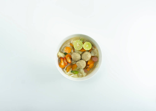 Meatball soup served in a white round bowl on a white background. - Valokuva, kuva